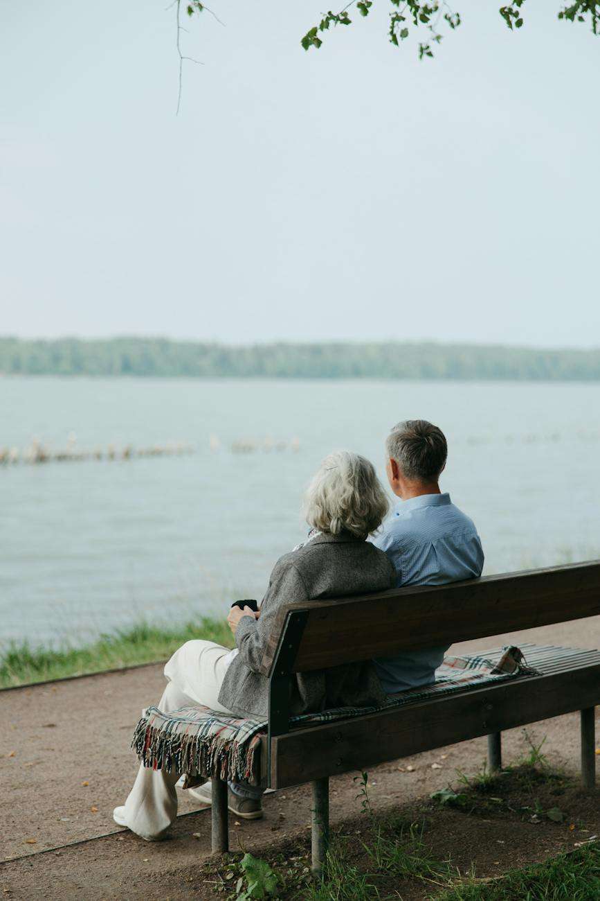 back view of an elderly couple sitting on a bench